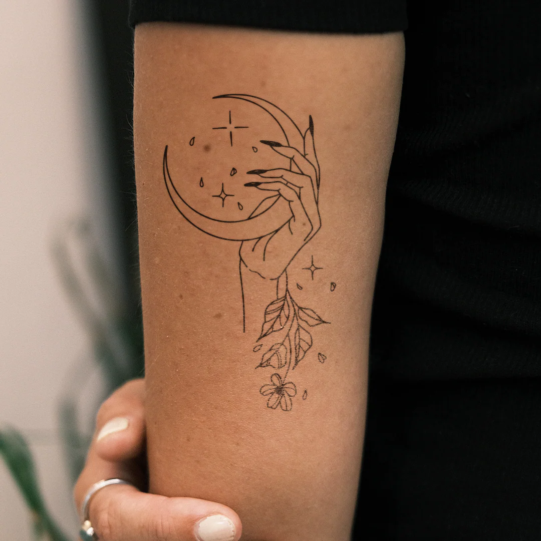 Main tenant une lune et une fleur